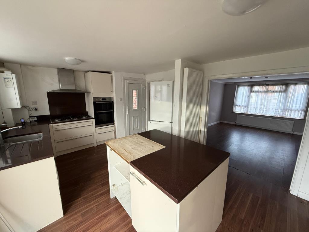 Lot: 40 - DETACHED HOUSE FOR IMPROVEMENT AND REPAIR - the kitchen and archway into the living room
